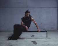 a woman sitting on a table in a dark room