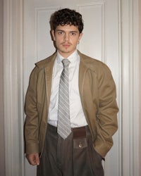 a man wearing a tan jacket and pants